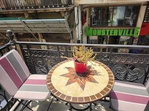 A balcony with a round table, two chairs, and a potted plant. - Unique! in the HEART of Athens Entire Building Apartment (Athina)