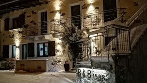 Un edificio con fachada de piedra, varias ventanas, una escalera y un letrero que dice 'B&B 1938'.
