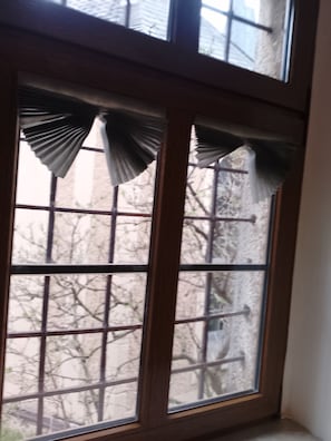 Una ventana con un marco de madera y un diseño de cuadrícula.
