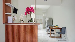 Une cuisine moderne avec un comptoir en bois, un coin repas avec une table et des chaises, et un îlot de cuisine agrémenté de plantes.