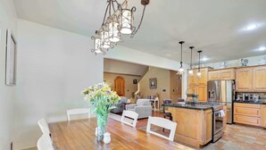 A spacious kitchen with wooden cabinets, a central island, and a dining area with a wooden table and chairs. - Last Chance Ranch - Hallsville TX (Hallsville)