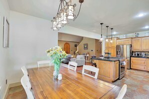 A spacious kitchen with wooden cabinets, a central island, and a dining area with a wooden table and chairs.
