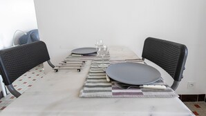 Et spisebord med stole, et glas og bestik.