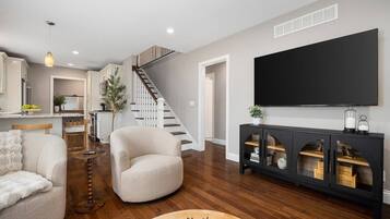A modern living room with a sofa, armchair, and a console table with decorative items.