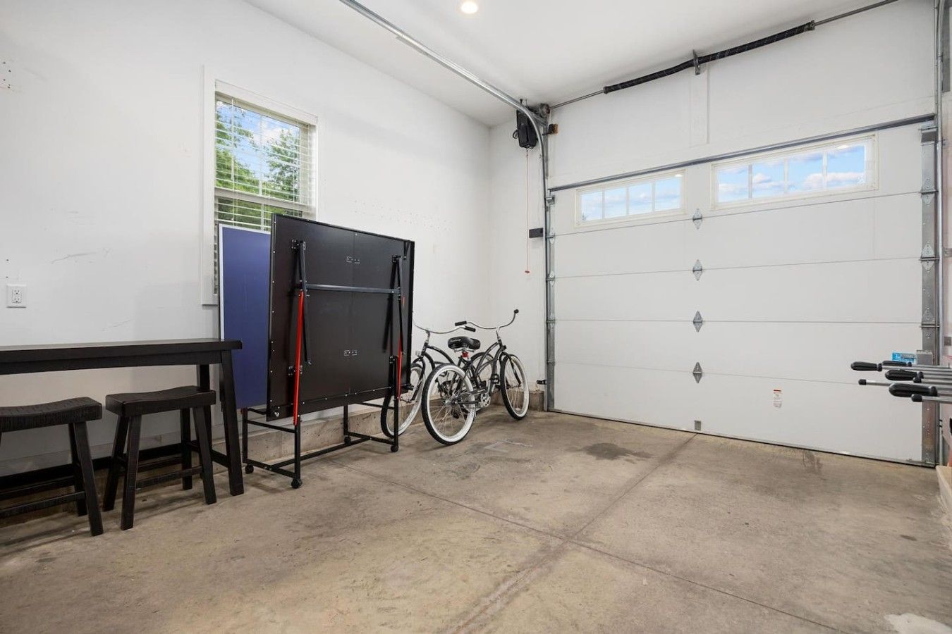 Un garage contenant un vélo, une table et un banc.