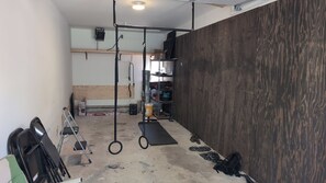 A gym with a pull-up bar, weight rack, and exercise mats.