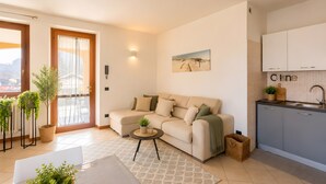 A modern living room with a sofa, a small coffee table, and a view of the outside.
