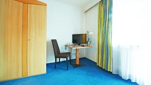 A room with a desk, chair, television, and a wardrobe. - Hotel Heli's (Hinterglemm)