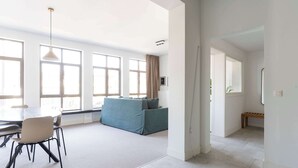 Ein geräumiger Wohnbereich mit Esstisch, Stühlen, einer Couch und einer Bank.