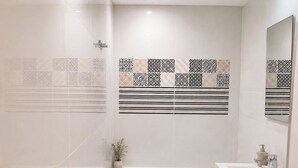 Un baño moderno con bañera, tocador y azulejos decorativos.