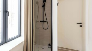 A glass-enclosed shower with a handheld showerhead, a wall-mounted faucet, and a handheld showerhead. - Elegant City Room near Antwerp Cathedral (Antwerpen)