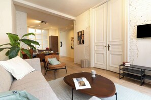 Ein Wohnzimmer mit einer Couch, einem Couchtisch und einem Essbereich mit Stühlen und einem Tisch.