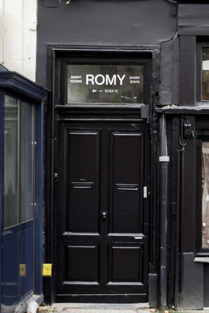Una porta doble negra amb un rètol a la part superior que diu 'SMART ROMY SHORT STAYS BY STAY-C'.