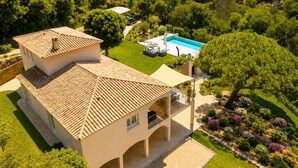 A two-story building with a tiled roof, a swimming pool, and a garden with various plants. - Luxury Villa for 12 Guests with Heated Pool in St. Maxime, La Nartelle Private Estate (Sainte-Maxime)