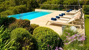 A swimming pool with lounge chairs and a garden area. - Luxury Villa for 12 Guests with Heated Pool in St. Maxime, La Nartelle Private Estate (Sainte-Maxime)