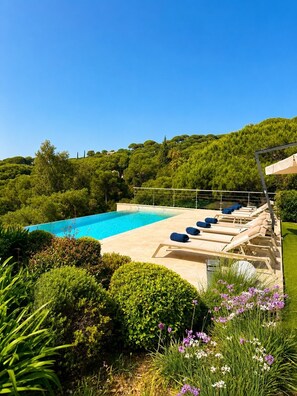 A swimming pool with lounge chairs and a garden area. - Luxury Villa for 12 Guests with Heated Pool in St. Maxime, La Nartelle Private Estate (Sainte-Maxime)