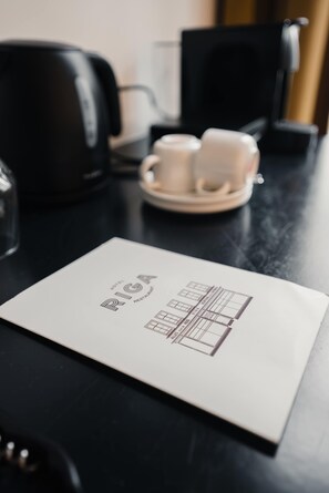 Una mesa con un menú, una cafetera y dos tazas.