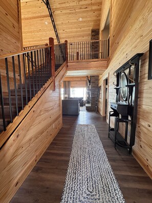 A wooden interior with a staircase, a rug, and a wall-mounted mirror. - Lake Daze . (Fort Gaines)