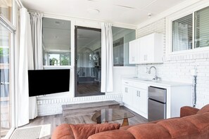 A modern kitchen with white cabinetry, a built-in oven, and a sliding glass door leading to a balcony. - 3-bedroom house in pleasant Fayetteville with AC and comfort (Fayetteville)