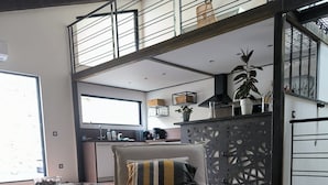 Een moderne slaapkamer met een bed, een bureau en een balkon.