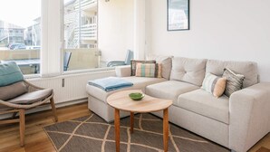 Un salon moderne avec un canapé, un fauteuil et une petite table.