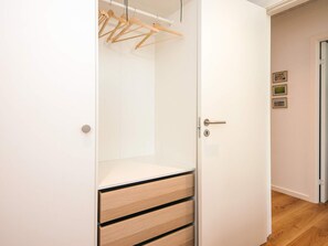 A white wardrobe with wooden hangers, a door with a handle, and a keyhole. - 4 Star Holiday Home in Fano (Fano)
