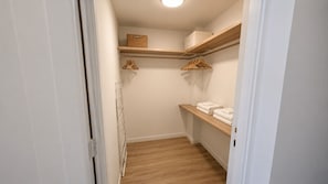 Ein kleiner Ankleideraum mit Holzböden, einer Kleiderstange und einer Heizung.