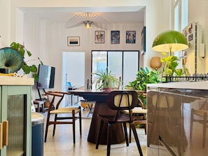 Eine geräumige Küche mit modernen Geräten, ein Essbereich mit Stühlen und ein großes Fenster, das für natürliches Licht sorgt.