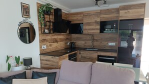 Una cocina moderna con armarios de madera, estufa integrada y un lavamanos.