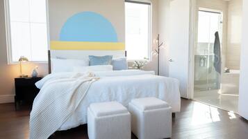 A bedroom with a bed, bedside tables, a ceiling fan, and a large window.