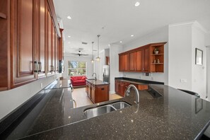 Eine moderne Küche mit Granit Arbeitsplatten, Holzschränken und einem integrierten Geschirrspüler.