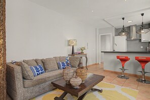 Ein Wohnzimmer mit einer Couch, einem Couchtisch und dekorativen Vasen.