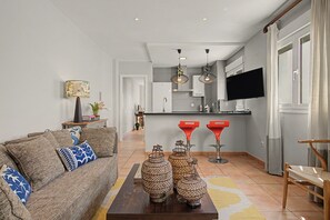 A modern living room with a sofa, coffee table, and decorative vases. - Mirador del Palmar Suite – Free Parking (Conil de la Frontera)