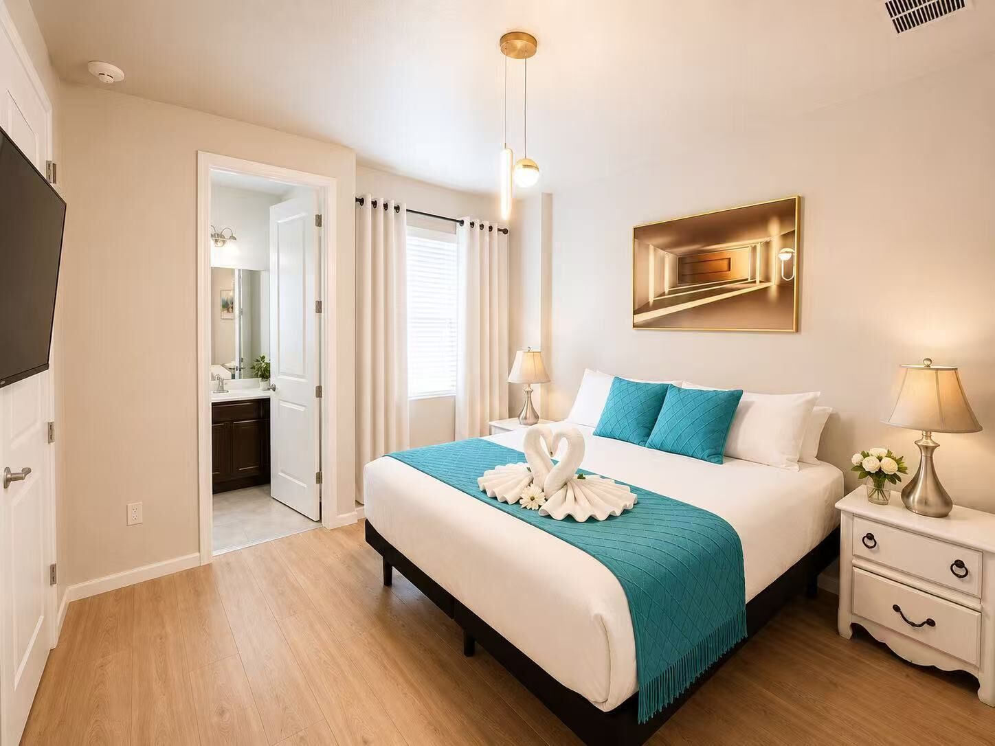 A hotel room with a bed, bedside tables, a mirror, a painting, and a TV.
