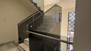 A modern staircase with glass railings and metal handrails, leading to an upper floor. - Brand New Rosarito Home w/ Ocean Views (rosarito)