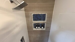 Eine Dusche mit Regendusche und einem wandmontierten Weinflaschenhalter.