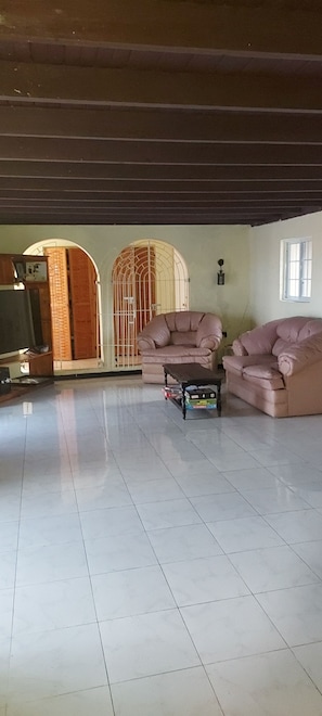 A spacious living room with two sofas, a coffee table, and a TV.