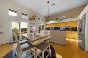 A modern kitchen with wooden cabinets, a central island, and a stainless steel refrigerator. - Panoramic Estate As Seen on 90 Day Fiancé (La Mesa)