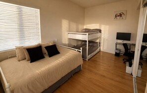 A bedroom with a bed, a bunk bed, a desk with a chair, and a wall-mounted TV. - Panoramic Estate As Seen on 90 Day Fiancé (La Mesa)