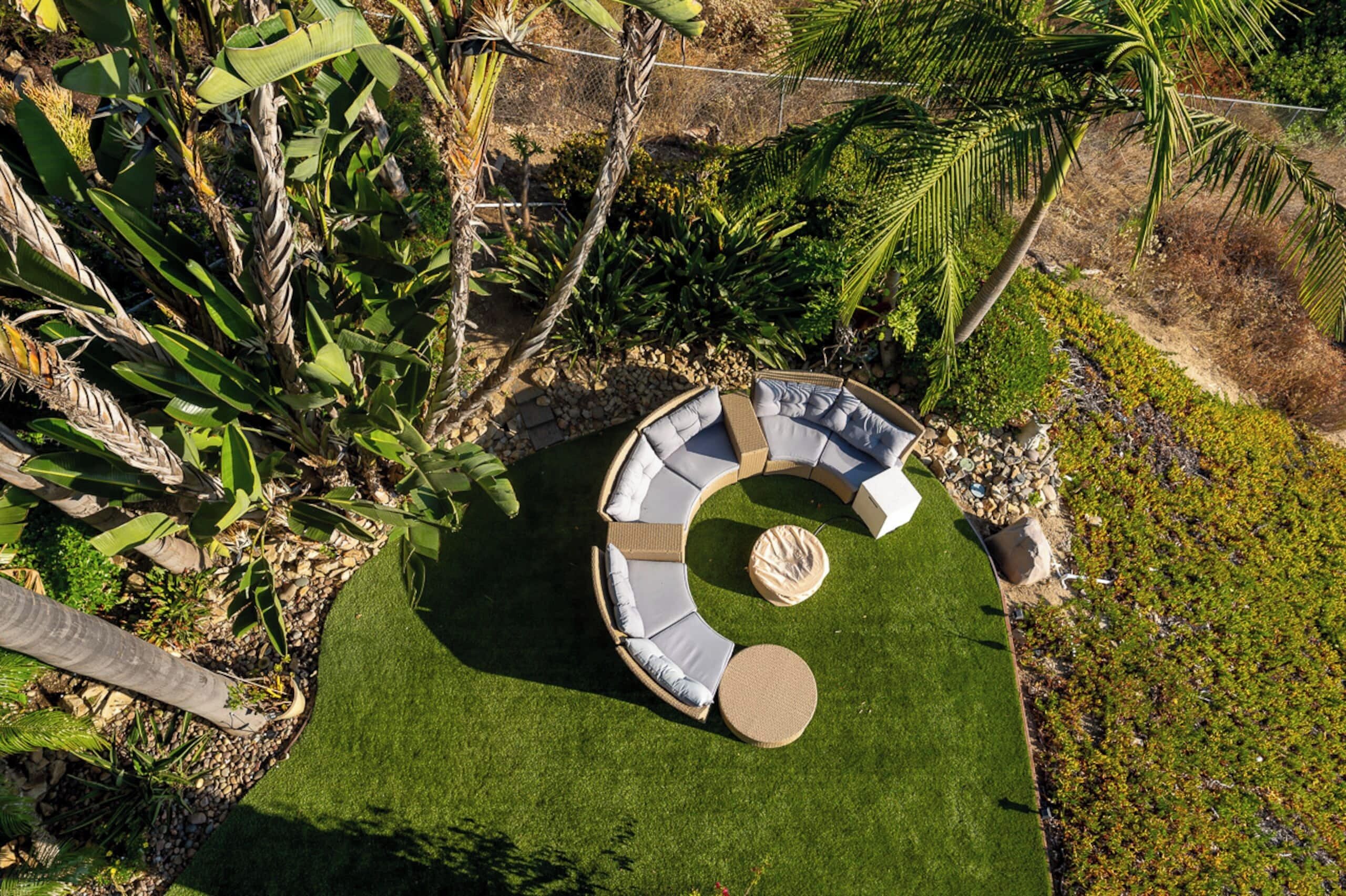 Un espacio de estar al aire libre circular con un brasero central rodeado de asientos acolchados.