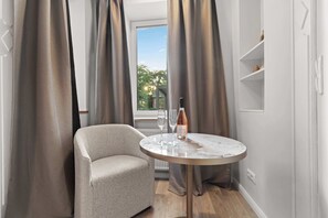 Ein Zimmer mit einem runden Tisch, einem Stuhl und einer Weinflasche.