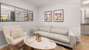 Ein modernes Wohnzimmer mit einer Couch, einem Sessel und einem runden Couchtisch.
