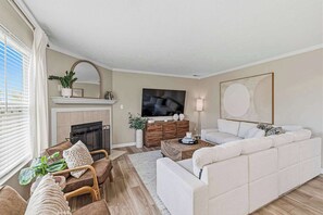 A living room with a fireplace, a sofa, a TV, and a coffee table.