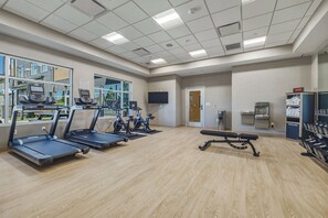 A fitness center with treadmills, stationary bikes, and a bench. - Cambria Hotel Bend - Mt. Bachelor (Bend)