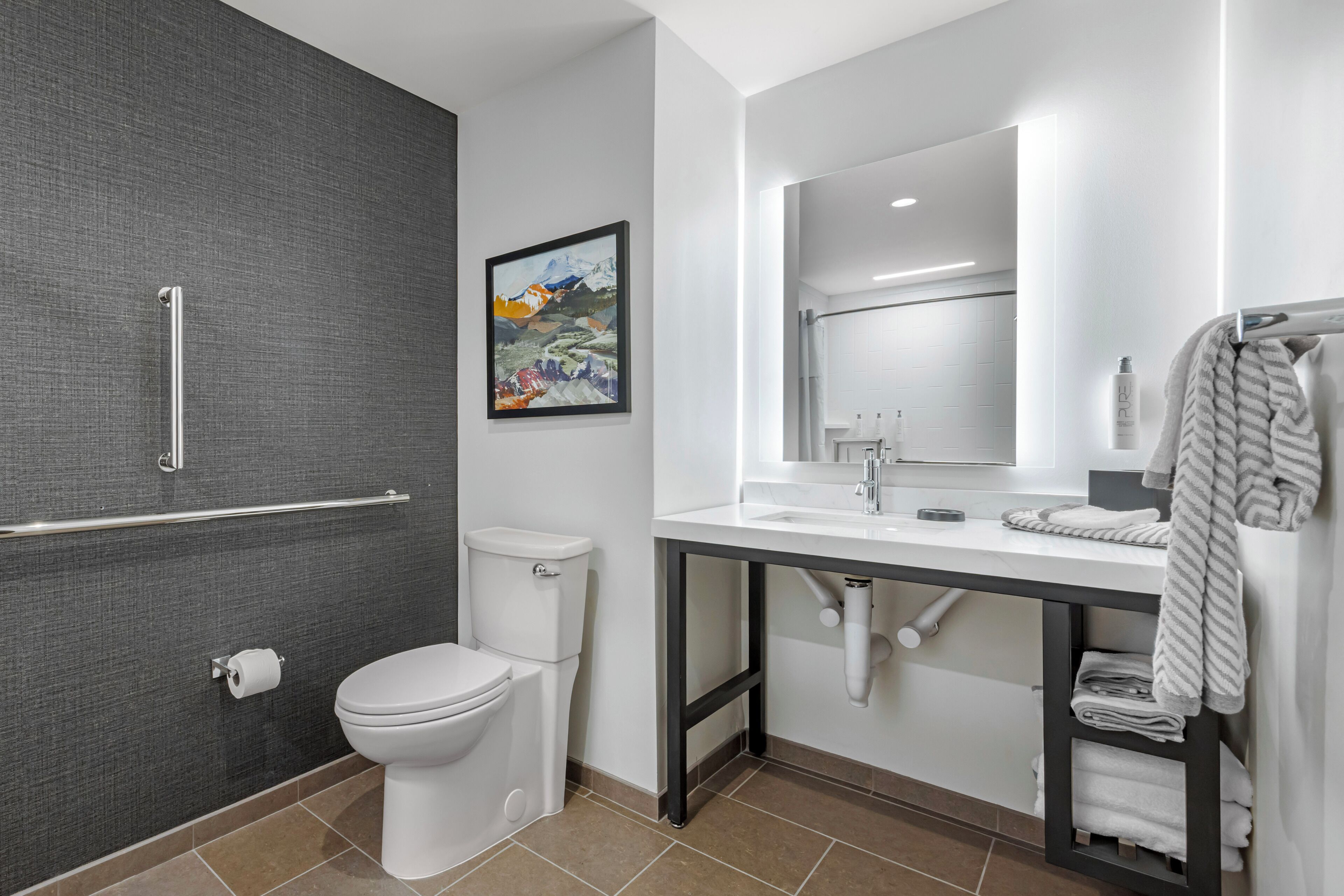 Un baño moderno con inodoro, lavamanos, espejo y zona de ducha.
