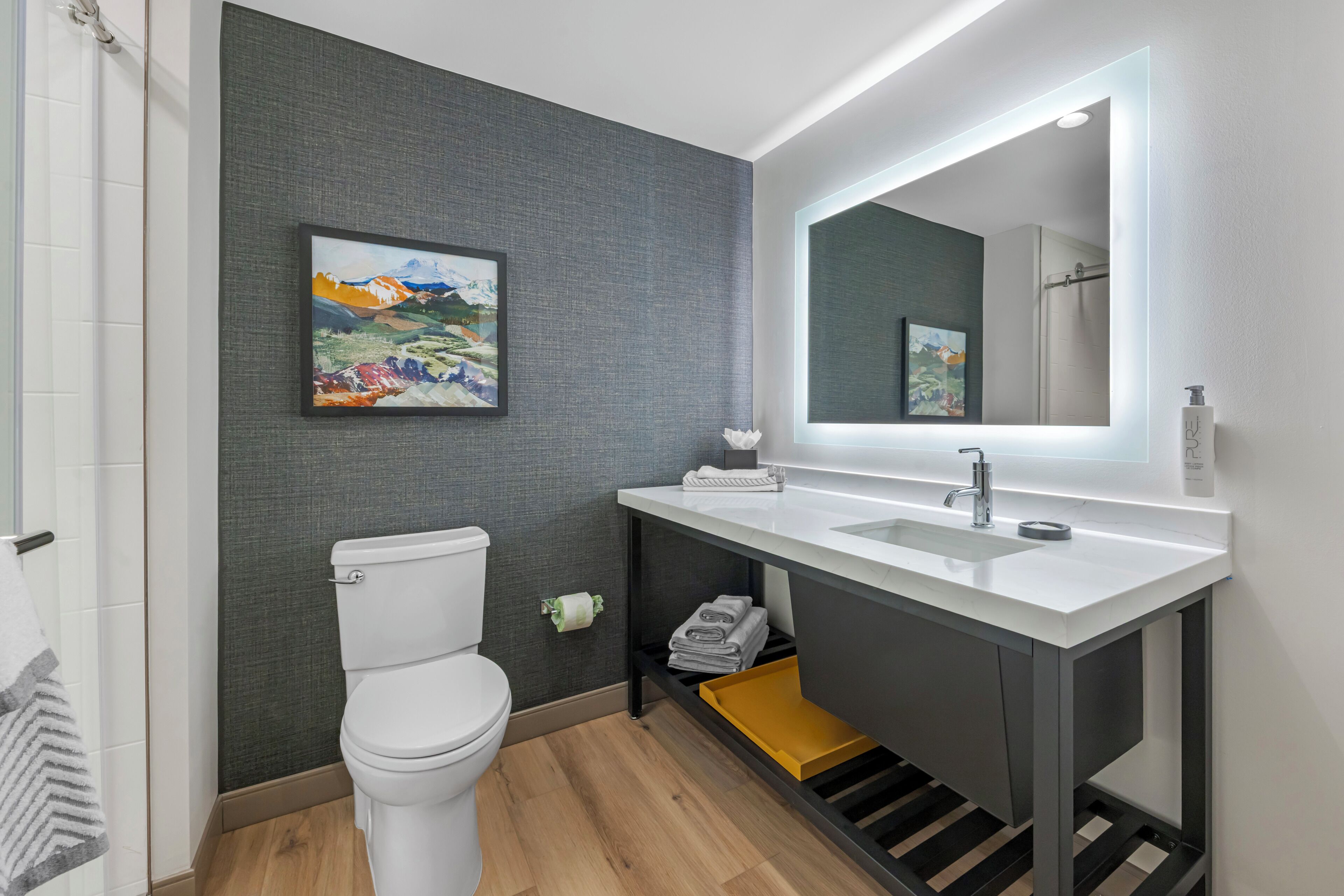 Un baño moderno con inodoro, lavabo y espejo.