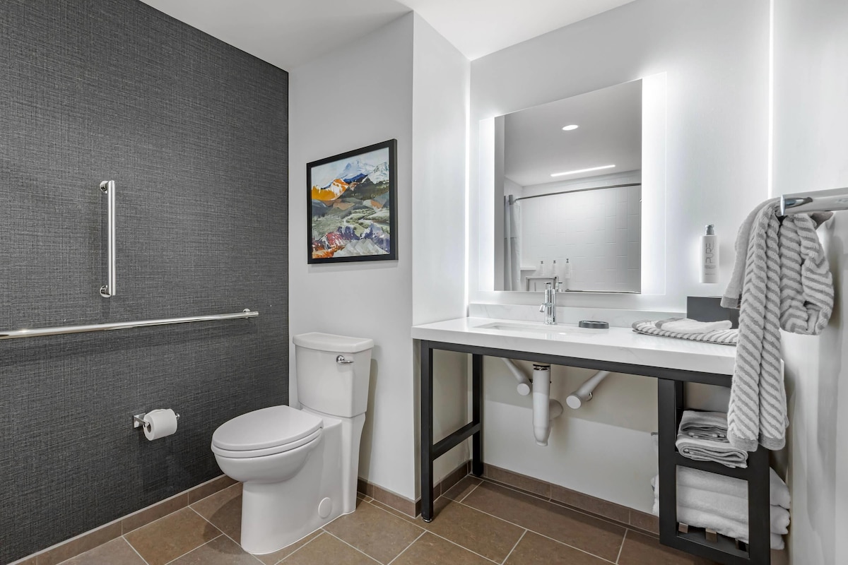 Un baño moderno con inodoro, lavabo y cabina de ducha.