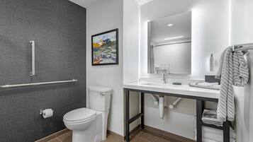 A modern bathroom with a toilet, a sink, and a shower area.