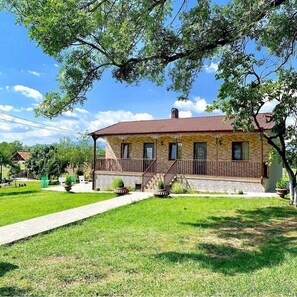 A two-story house with a balcony, a front porch, and a paved driveway. - Relax in Nature. Cozy Georgian resort with pool, stunning Views &Tranquility (Tskaltubo)