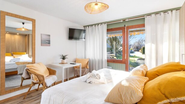 Une chambre d’hôtel équipée d’un lit, d’un bureau, d’une chaise, d’une télévision et offrant une vue sur l’extérieur.